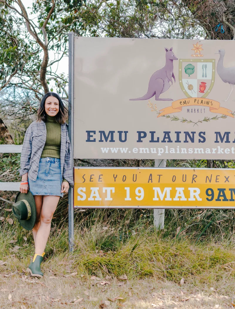 Dani beside a sign