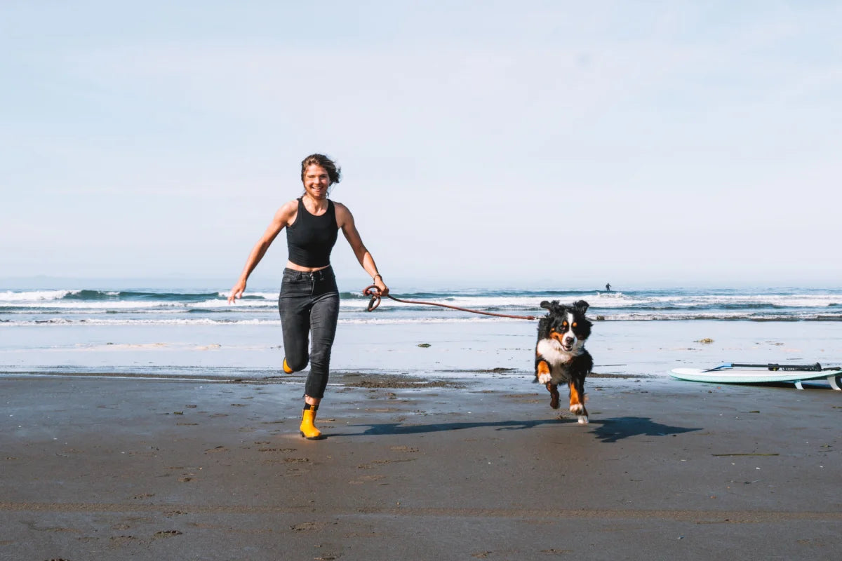 Sky running on the beach with her dog