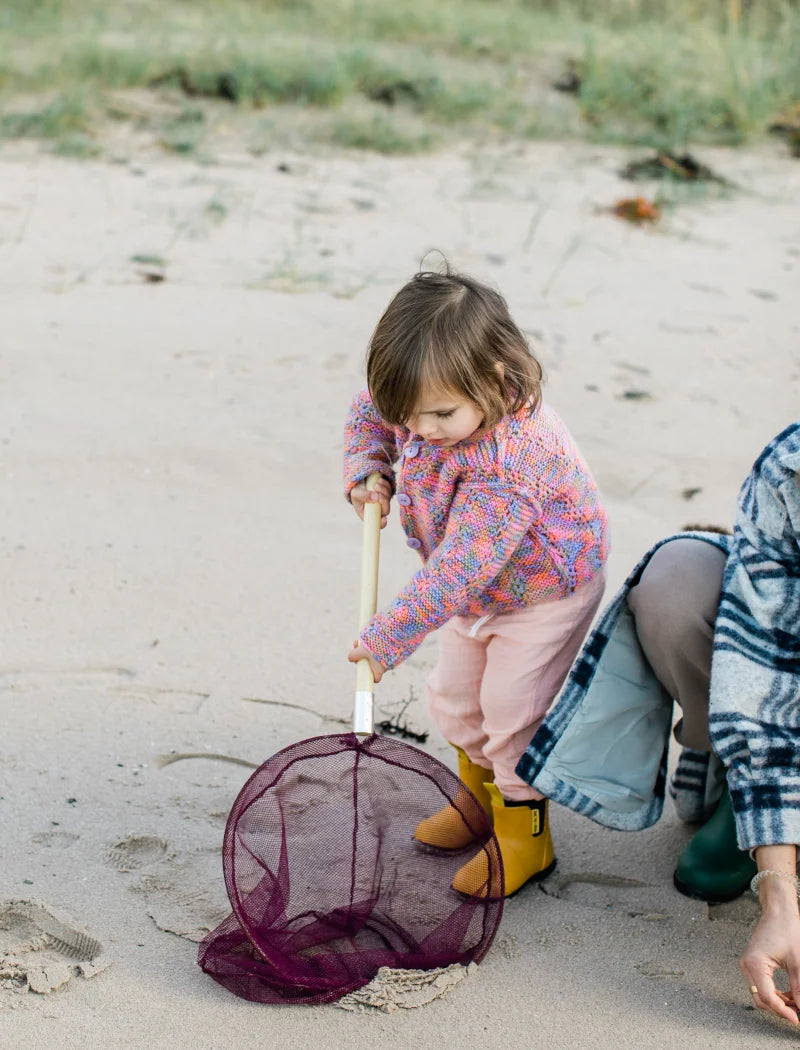 kid holding fishing net wearing yellow boots