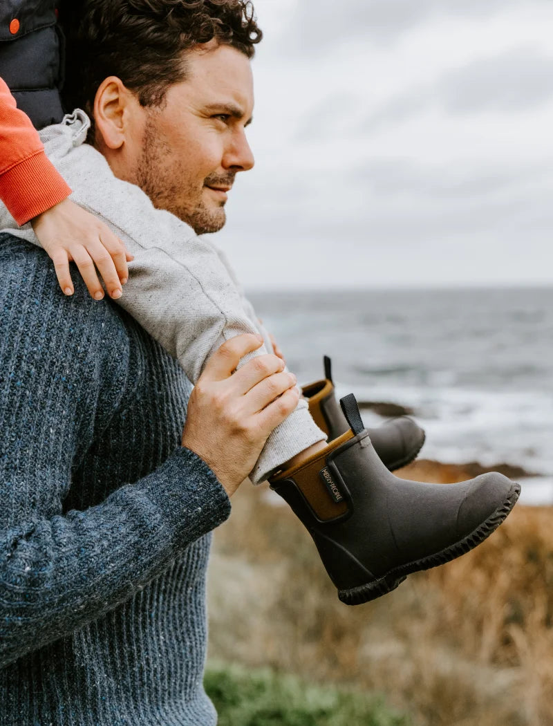 son sitting on father wearing boots