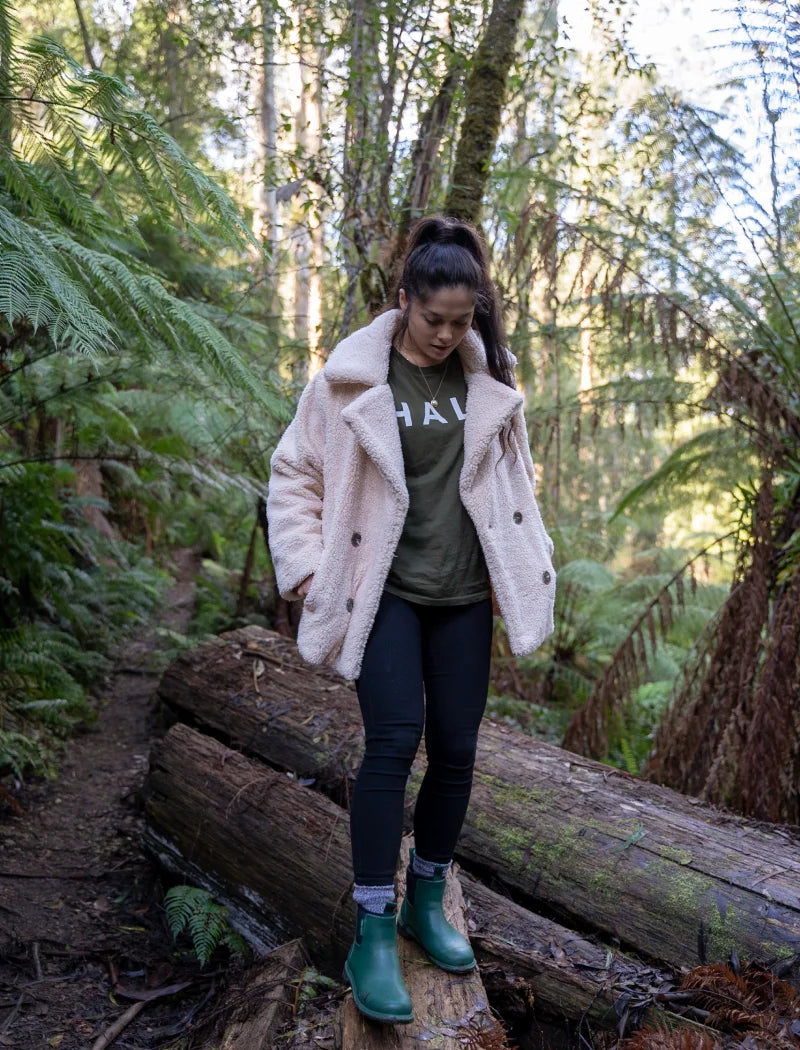 standing on the logs with green boots