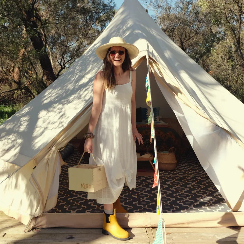 white dress and yellow boots infront of the tent