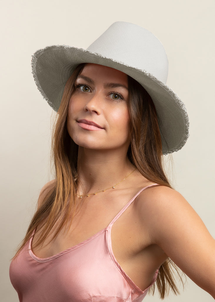 Woman wearing silver panama hat with pink silk dress.