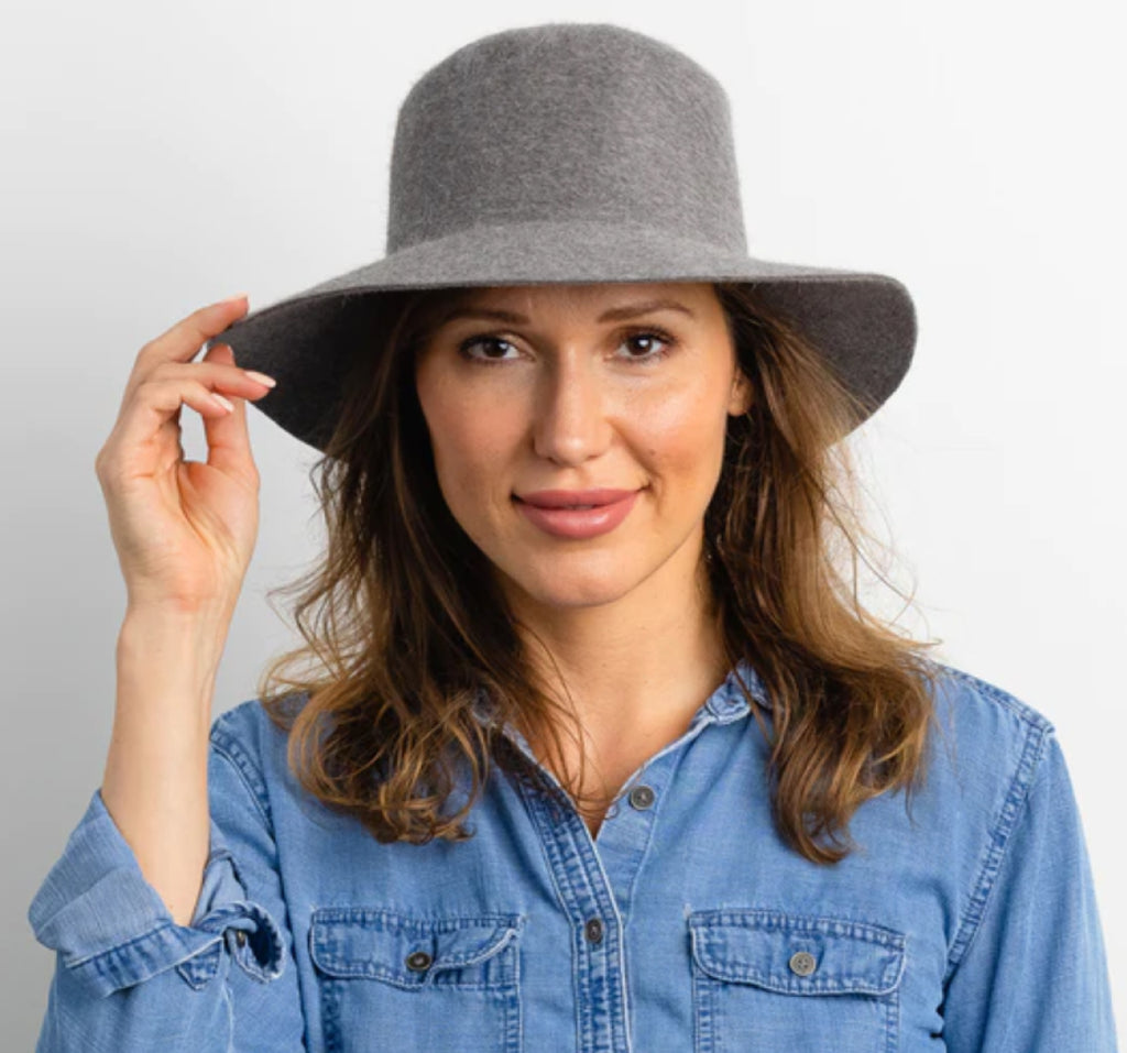 Woman with long dark hair wearing fedora hat.