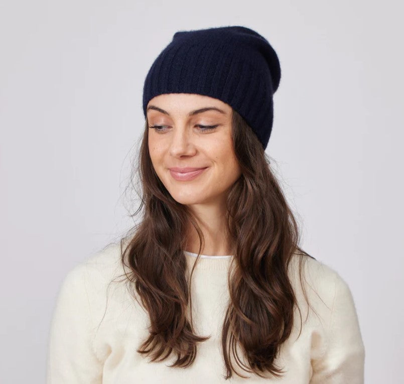 Woman with long hair wearing dark slouchy beanie.