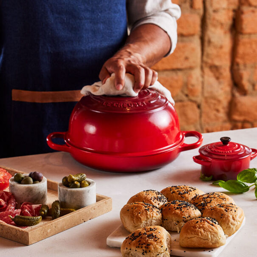 https://cdn.shopify.com/s/files/1/2373/0269/products/le-creuset-bread-oven-cerise-lifestyle_512x512.png?v=1675188122