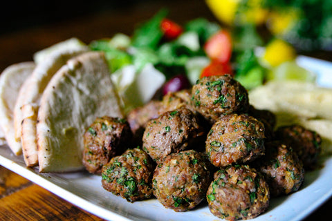 Lamb meatball platter with pita, salad, olives, and hummus