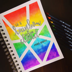 brush lettering with rainbow background