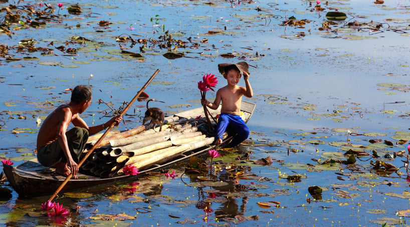 Boy holding Lotus Flower on the river