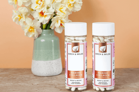 high strength marine collagen capsules from birch and wilde with yellow flowers in a pale green vase in the background