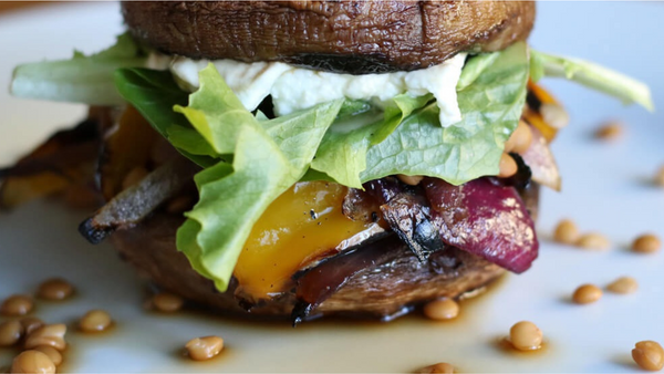 image of a tasty looking portobello and grilled veggie burger served with goats cheese