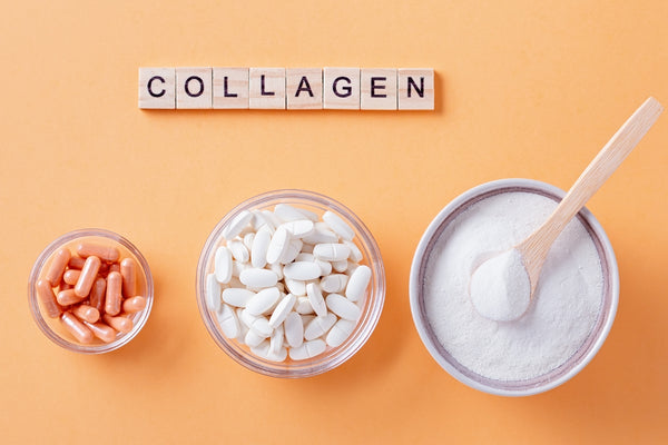 image with orange background and letter tiles spelling out the word collagen. There are 3 bowls and 2 contain collagen supplement capsules and one contains white collagen powder. 