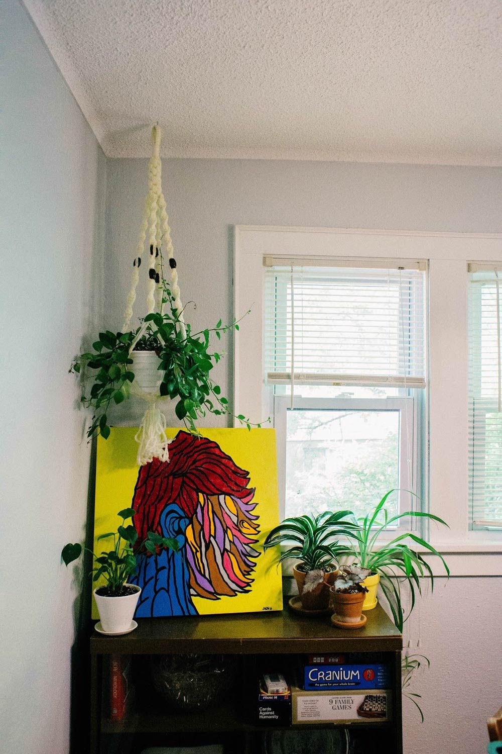 Hanging plant near dresser with art