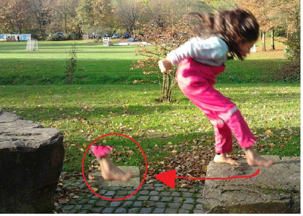 Ein Kind beim Aufsetzen der Füße nach einem Sprung; das Kind ist Barfuß, die Haltung des Fußes beim Aufsetzen wird zusätzlich durch eine Nahaufnahme hervorgehoben.