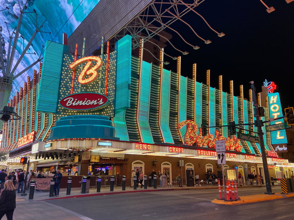 Ein Blick auf eine Straßenecke in Las Vegas. Im Zentrum die türkis, gelb und rot beleuchtete Fassade des Hotels Binion's.