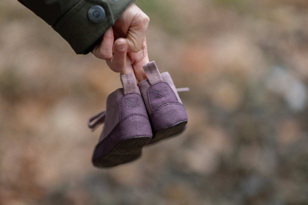 Close-up: A hand holding a pair of Heide Refoxed; the heel side is turned towards the camera; the background is blurred