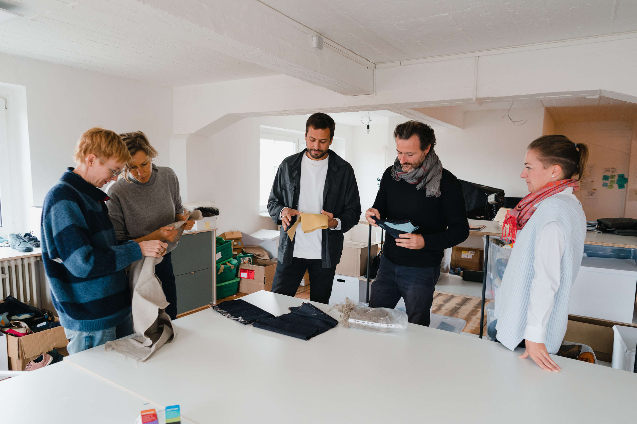 Employees of Wildling Shoes and VirgoCoop standing in a semicircle around your table in the Wildling Shoes studio.