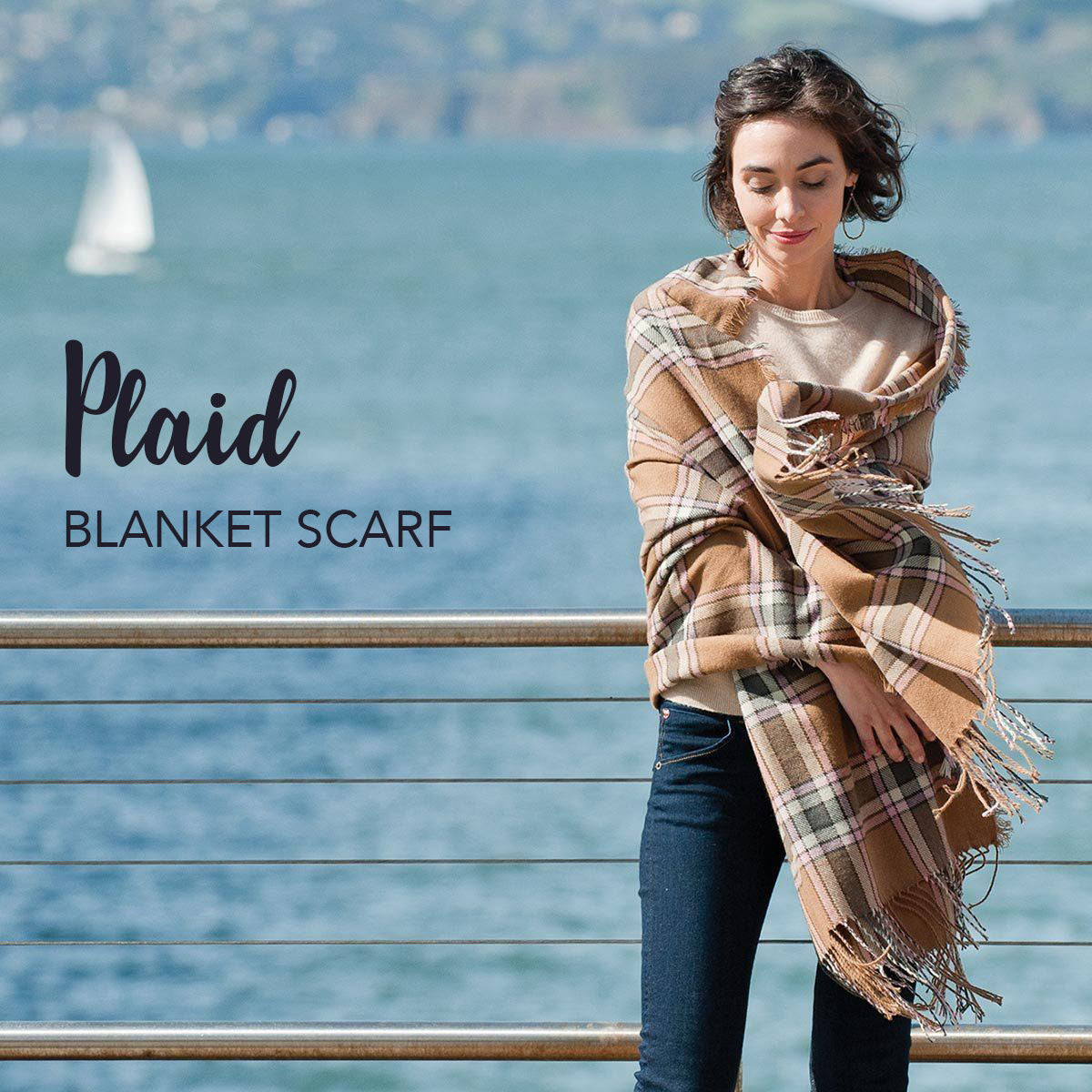 woman wearing a tan plaid blanket scarf by the bay