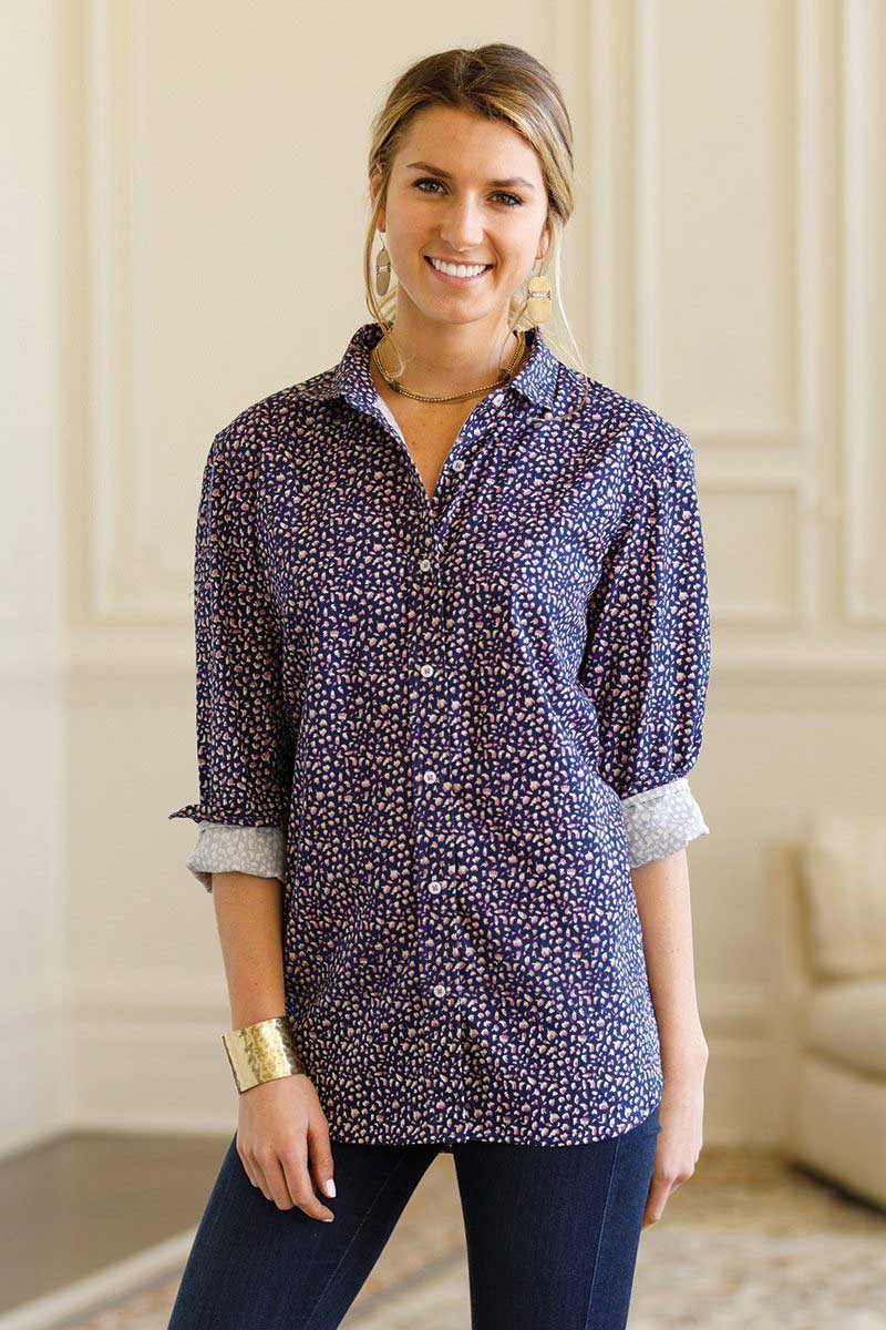 Woman wearing navy blue floral print button down shirt with dark jeans