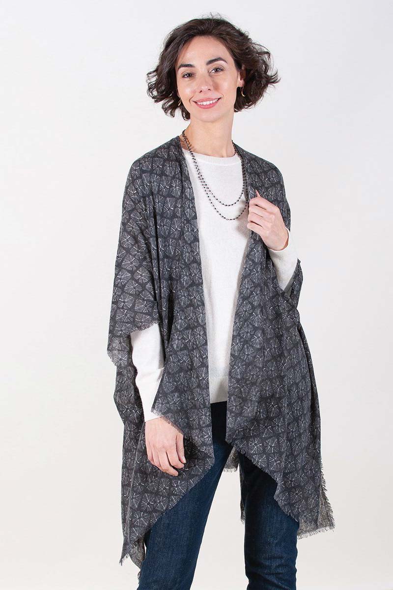 woman wearing black starburst print fringe kimono with sweater and jeans