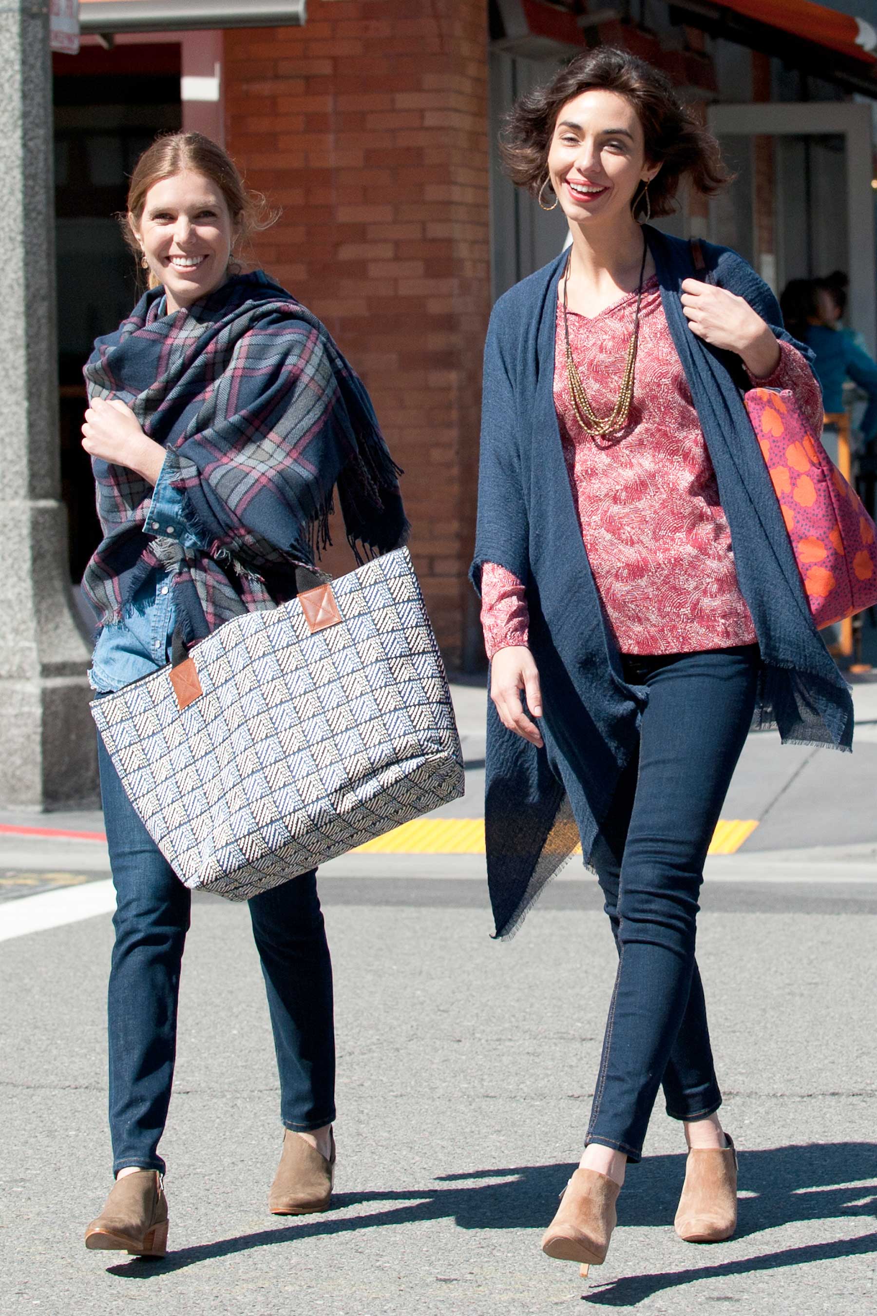 two women walking across the street in plaid wrap, kimono wrap, and tote bags