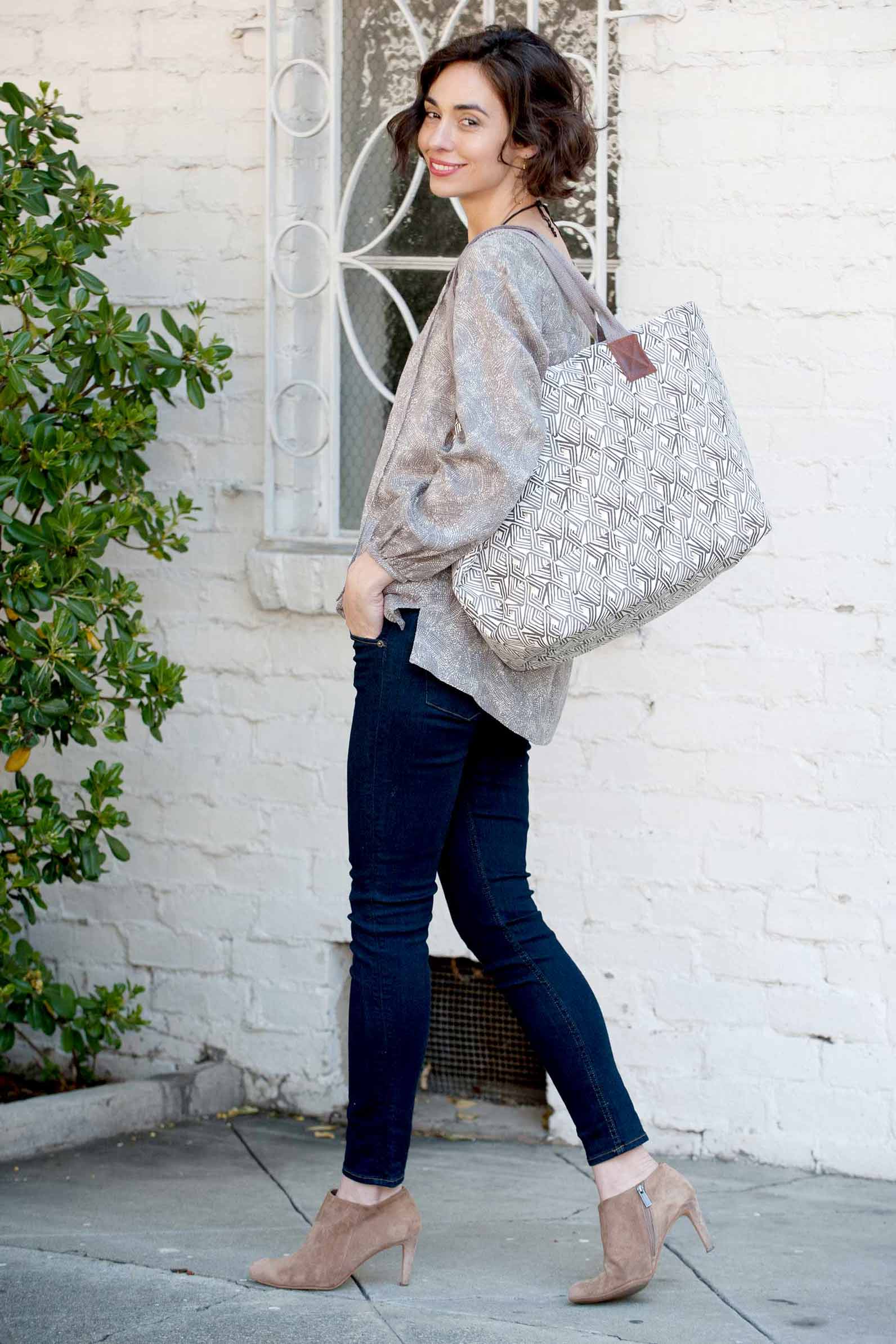 woman wearing grey tunic and grey tote bag with jeans