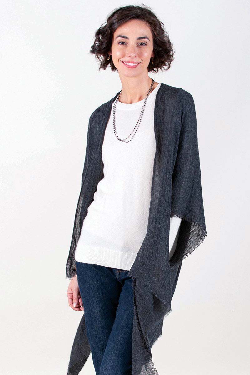woman wearing black fringe kimono over sweater and jeans