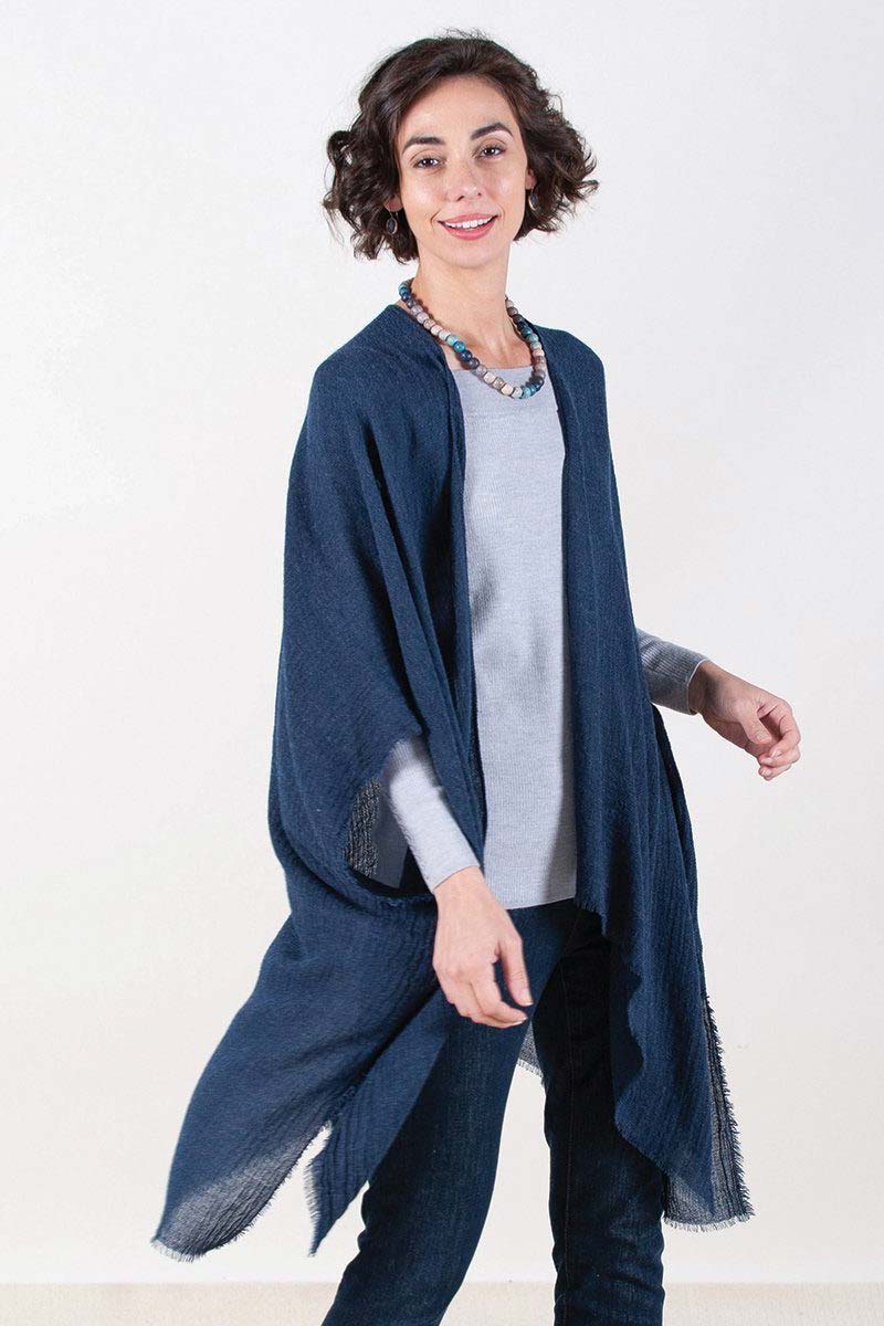 woman wearing blue fringe kimono over sweater and jeans