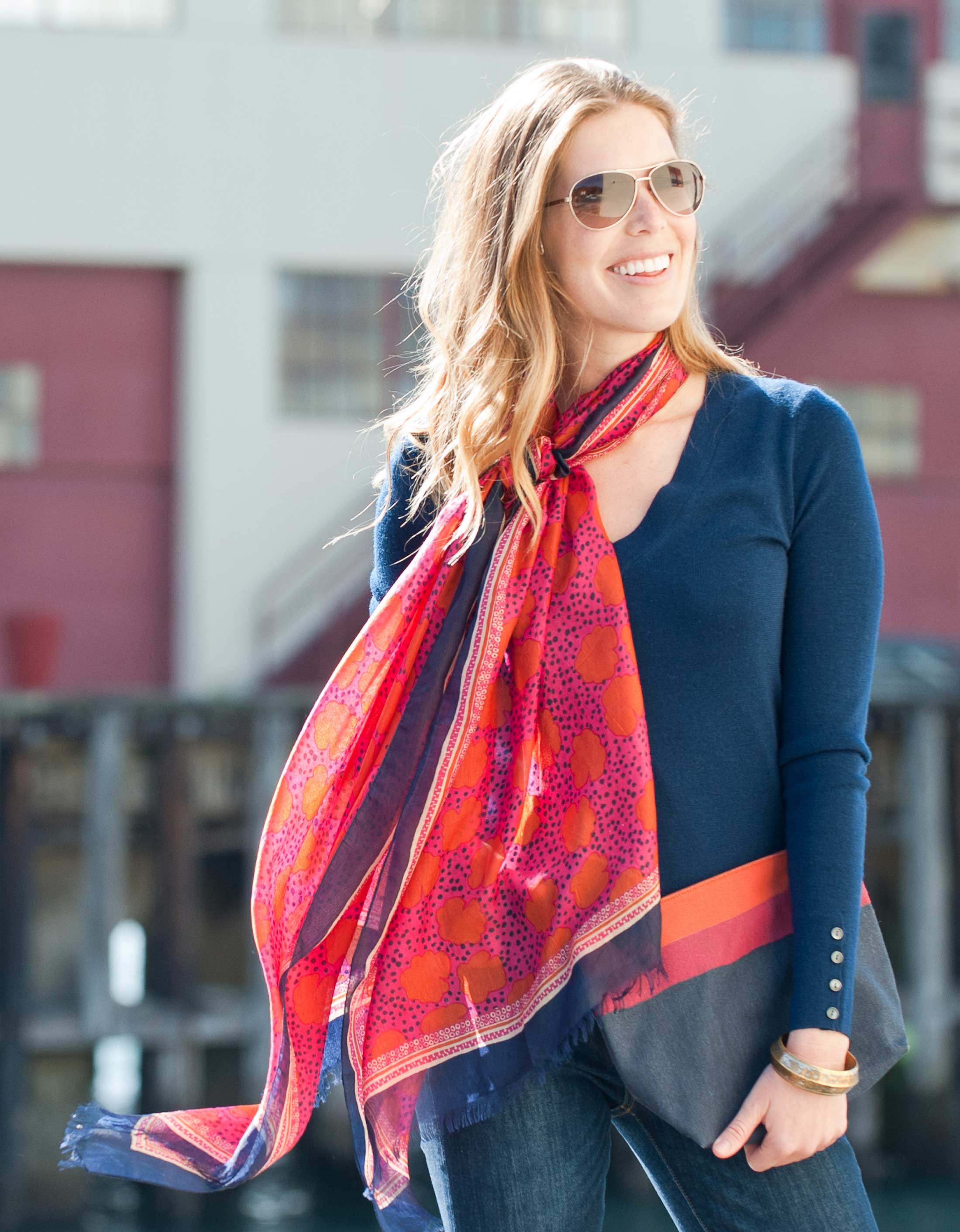 woman wearing navy sweater and red floral print silk scarf