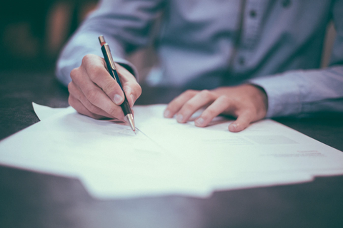 Person writing on sheets of paper