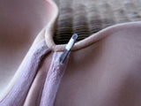 Image of an underwire popping through the centre gore of a bra.