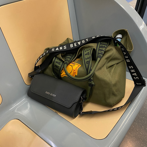 Image of Natural Fibre Welding Mirum handbag by Sans Beast alongside a cotton canvas tote sitting on a yellow train seat in Milan