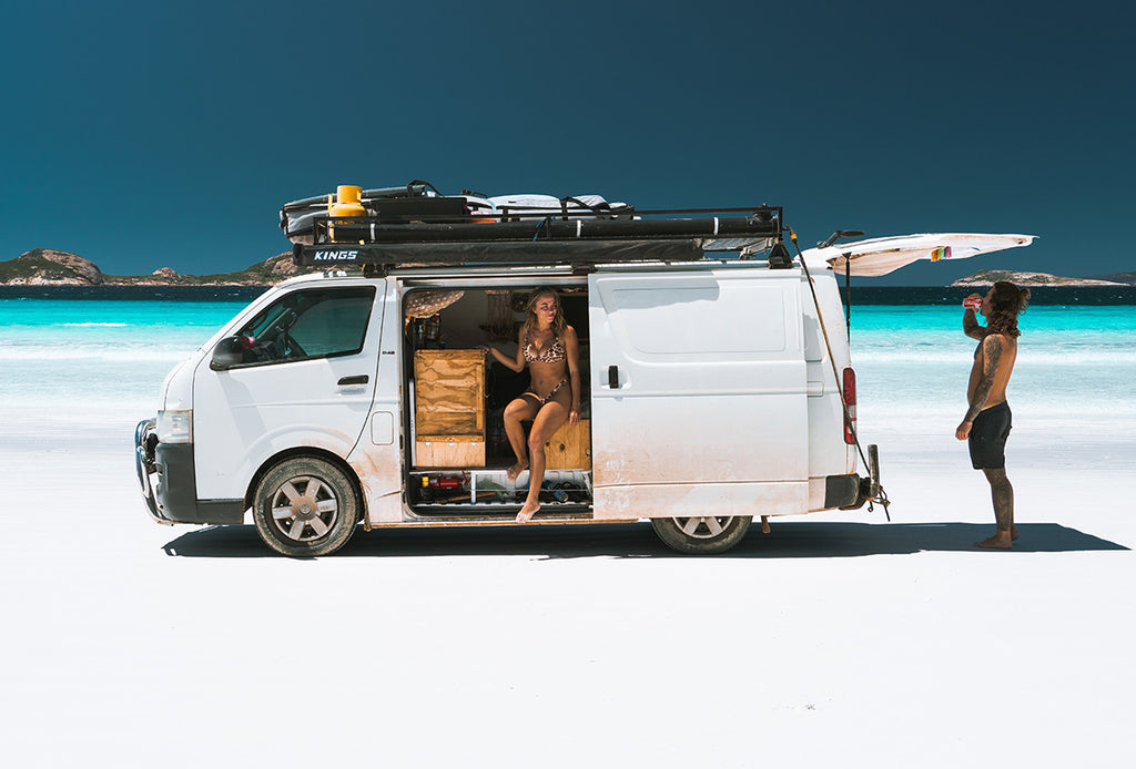 Sarah Byden in her van on a white beach