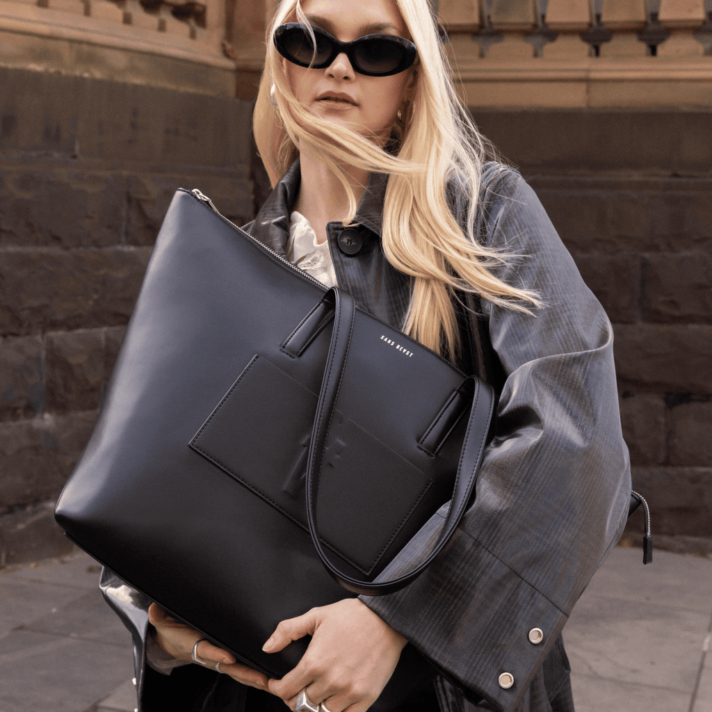 Elsa holds the Nomad Tote in Noir