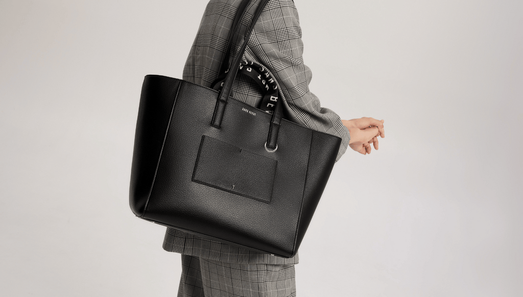 Cropped image of Eugenia carrying the Archive Tote in Noir