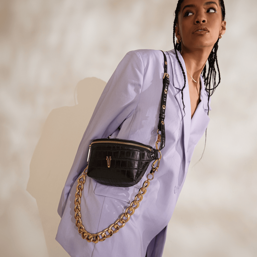 April wears a Lavender toned suit with the Tiny Spark in Noir + Elemental Chain Strap in Gold