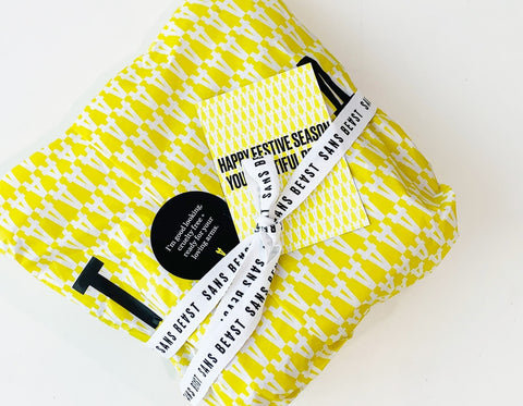 A Sans Beast gift wrapped parcel in tones of yellow, black + white.