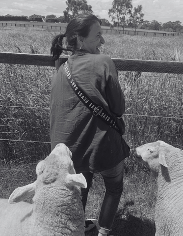 VF smiling as she feeds sheep at Edgar's Mission