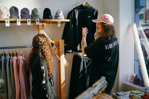 A woman and a man shop for clothes at the Homie store.