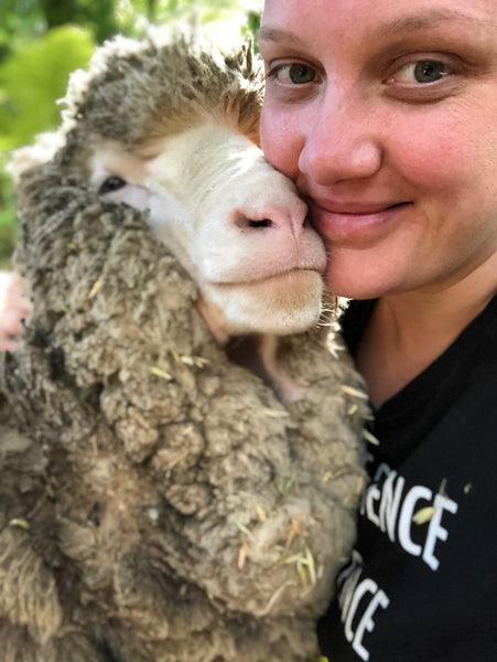 Joanne Lee pictured cuddled up to a sheep. 