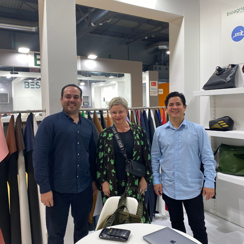An image of Cathryn Wills founder of Sans Beast standing with Adrian Lopez Velarde and Marte Cazarez founders of Desserto, all standing at the Desserto stand at Lineapelle