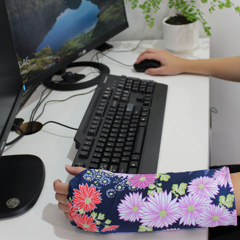 Girl wearing decorative arm cast cover at computer desk