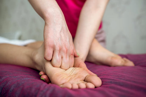therapist's hand doing foot massage