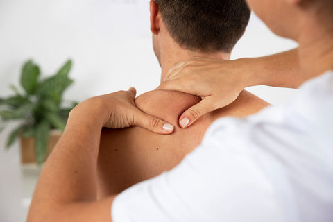 therapist doing shoulder massage to a male client