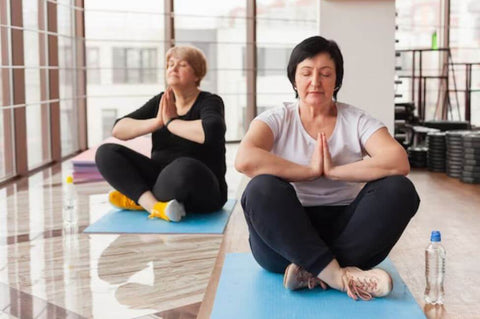 senior women meditating on a yoga mat