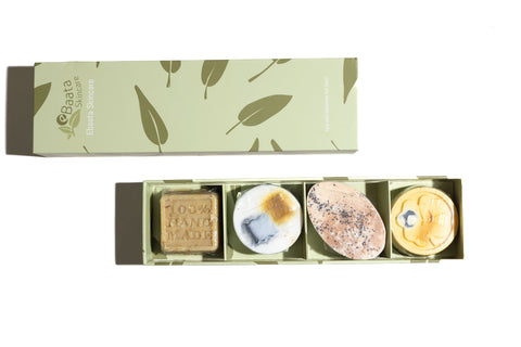 A green gift box with four mini soaps