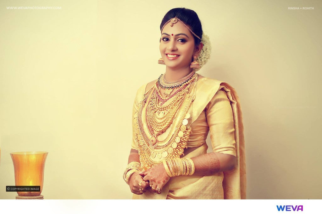 Photo of Malayali bride in gold jewellery and white saree.