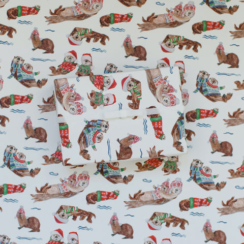 otter wrapping paper in christmas outfits