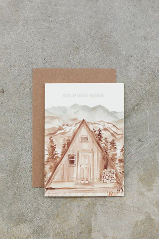 Greeting Card with wording saying You're my favorite Adventure and featuring an illustrated A-frame cabin in the mountains