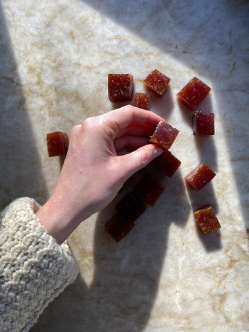 Hand reaching for elderberry herbal gummy